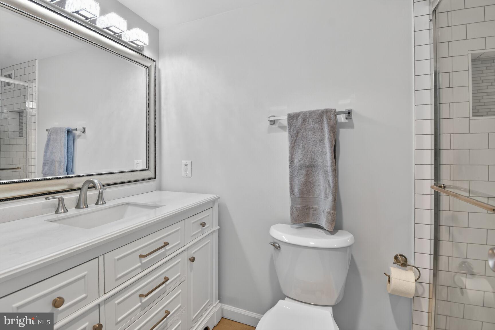 5500 Friendship Boulevard, Unit 1714N Chevy Chase, MD 20815 - Photo 16 of 53 a bathroom with a granite countertop toilet a sink and a mirror