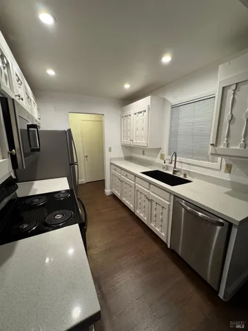 a kitchen with stainless steel appliances a sink stove and refrigerator