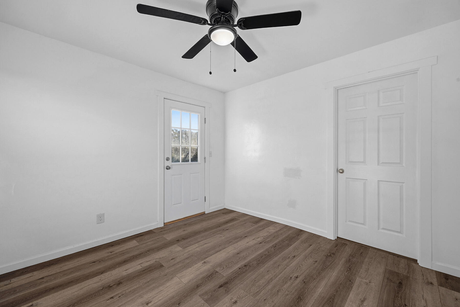 29205 Road 210 Exeter, CA 93221 - Photo 38 of 44 an empty room with wooden floor ceiling fan and windows