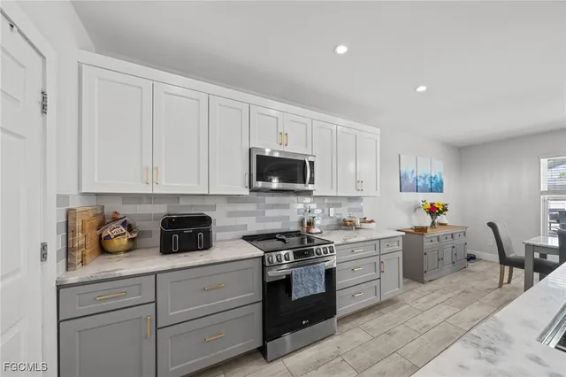 a kitchen with stainless steel appliances granite countertop a stove and white cabinets