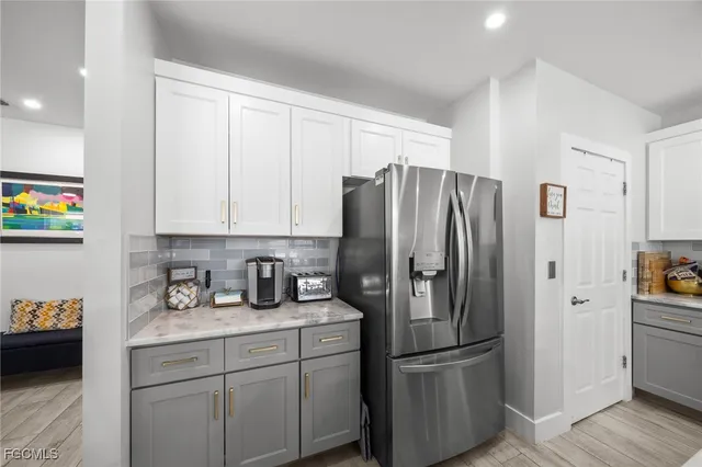 a kitchen with stainless steel appliances granite countertop a refrigerator and a stove top oven