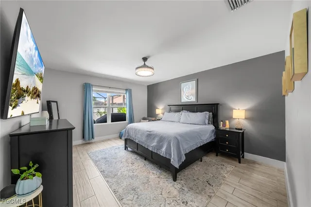 a spacious bedroom with a bed and a flat screen tv