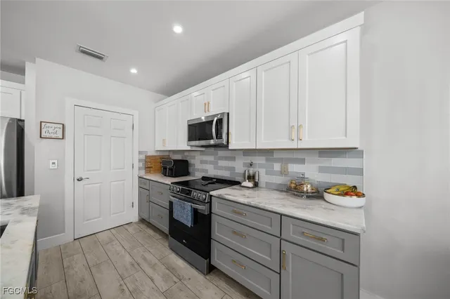 a kitchen with stainless steel appliances granite countertop a stove a sink and a refrigerator
