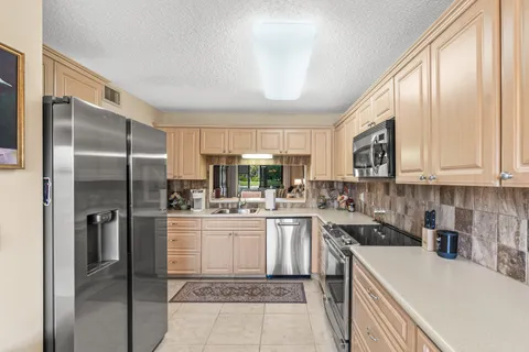 a kitchen with a sink a refrigerator and cabinets