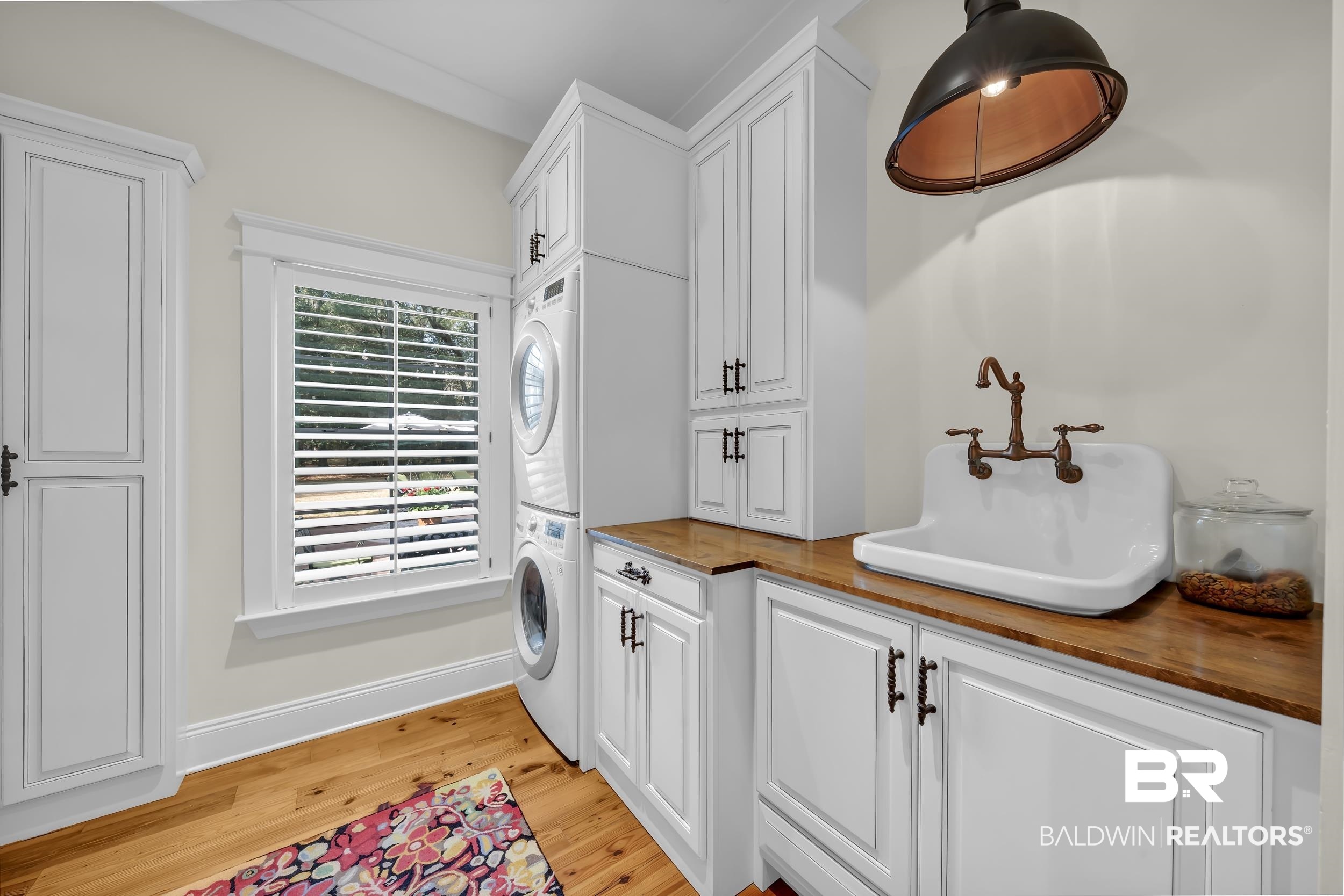 12161 Jessamine Street Magnolia Springs, AL 36555 - Photo 24 of 70 Laundry room with cabinet space, light wood-style floors, and stacked washing machine and dryer