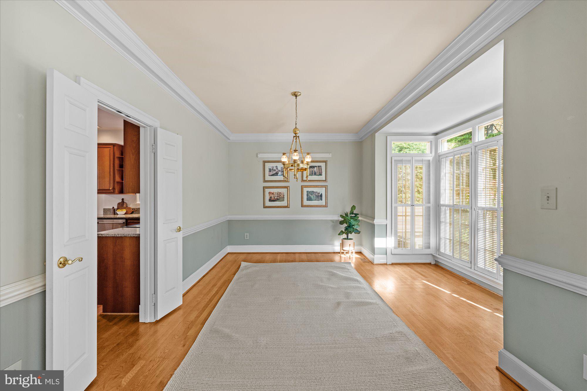 8025 Rising Ridge Road Bethesda, MD 20817 - Photo 14 of 34 a spacious bedroom with a large bed and a chandelier