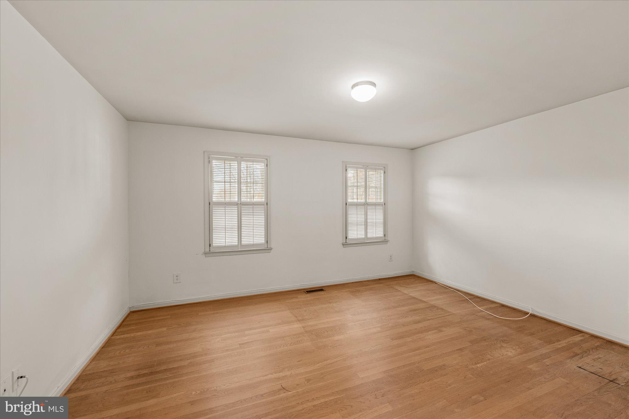 8025 Rising Ridge Road Bethesda, MD 20817 - Photo 22 of 34 an empty room with wooden floor and windows