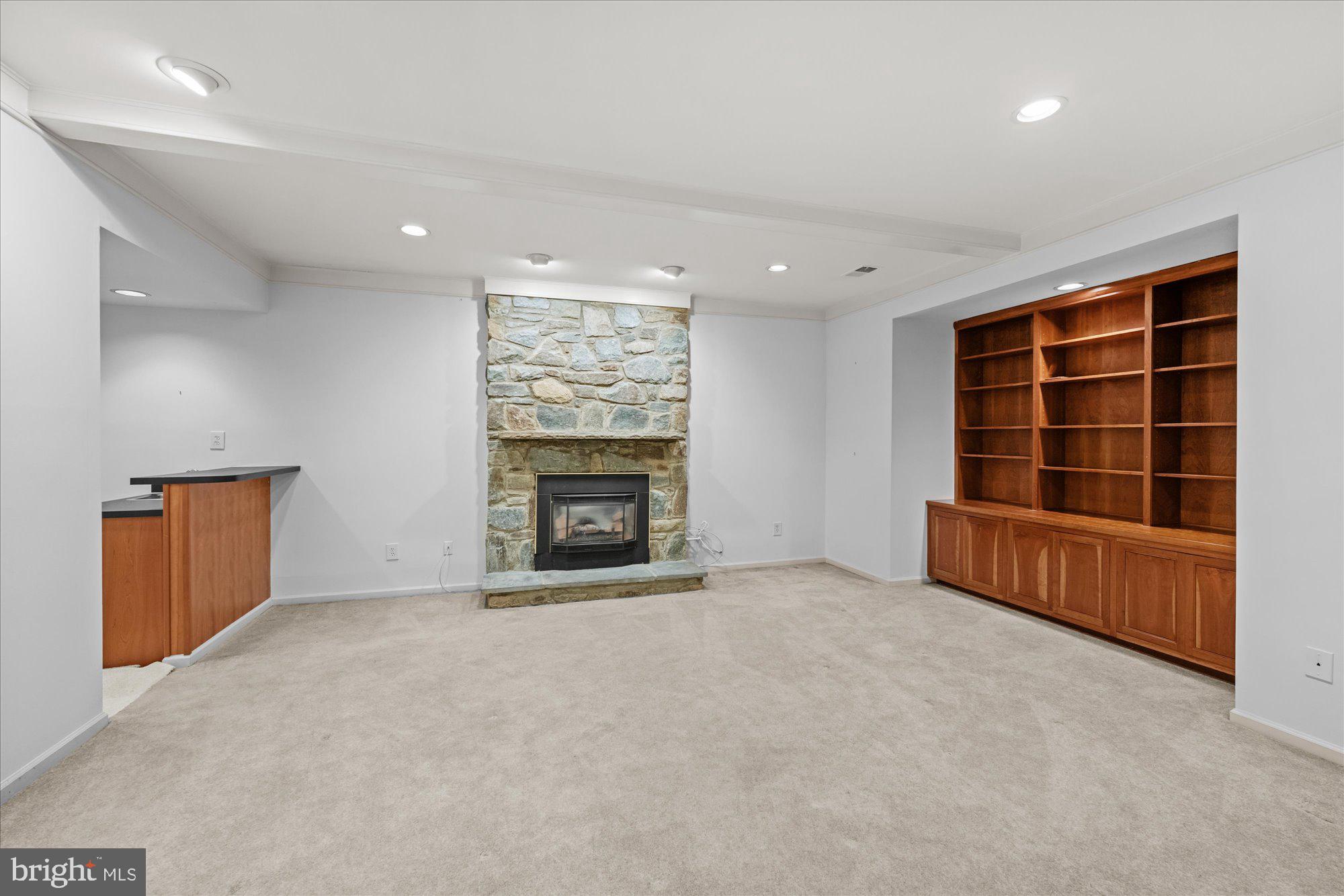 8025 Rising Ridge Road Bethesda, MD 20817 - Photo 24 of 34 an empty room with a fireplace cabinet and windows