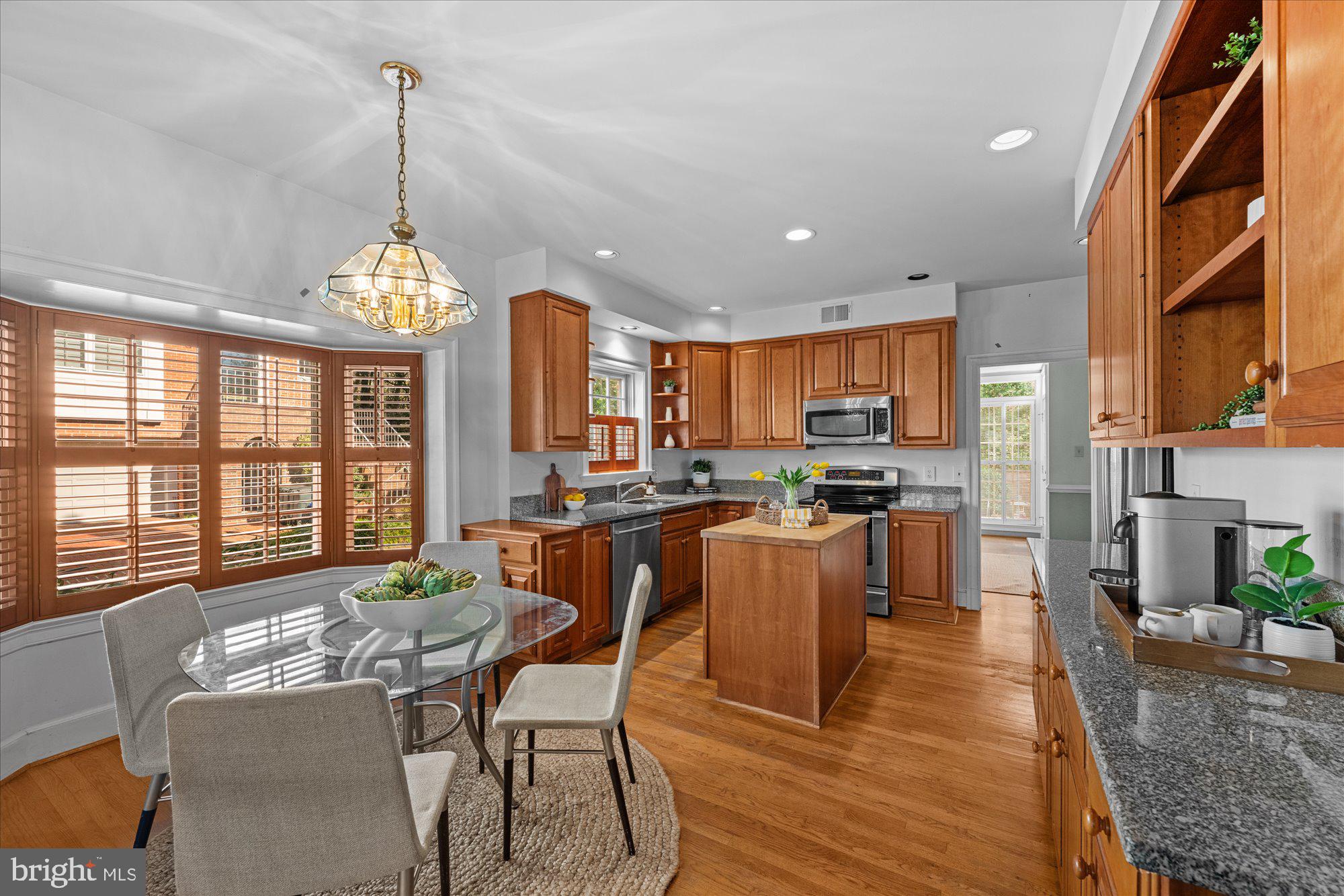8025 Rising Ridge Road Bethesda, MD 20817 - Photo 8 of 34 a view of a dining room and livingroom with furniture wooden floor a chandelier