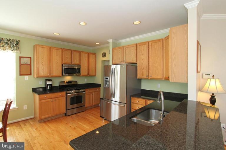 18409 Cornflower Road Boyds, MD 20841 - Photo 7 of 24 a kitchen with stainless steel appliances granite countertop a refrigerator a stove top oven a sink and dishwasher