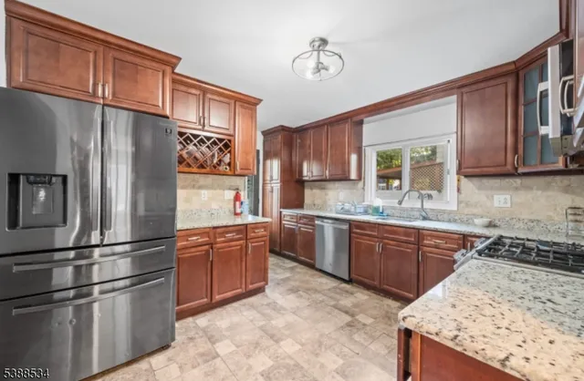 a kitchen with stainless steel appliances granite countertop a refrigerator sink and stove