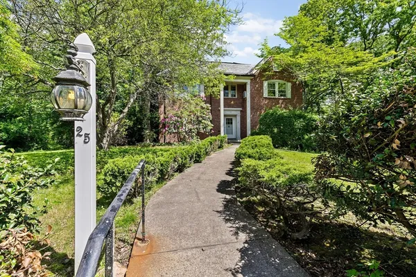 a front view of a house with a yard and fountain