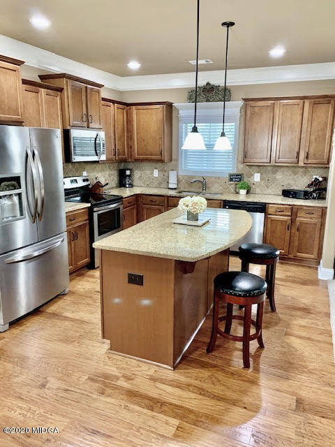 203 Longbridge Way Perry, GA 31069 - Photo 13 of 31 a kitchen with stainless steel appliances granite countertop a sink a stove a refrigerator cabinets and chairs