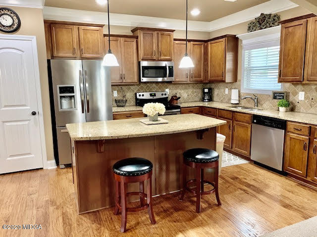 203 Longbridge Way Perry, GA 31069 - Photo 14 of 31 a kitchen with stainless steel appliances granite countertop a refrigerator a stove top oven a sink dishwasher and white cabinets with wooden floor