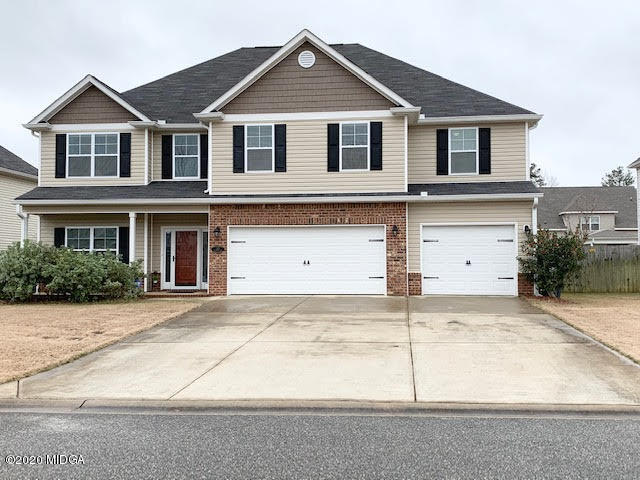 203 Longbridge Way Perry, GA 31069 - Photo 3 of 31 a front view of a house with a yard and garage