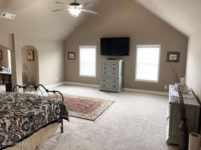 203 Longbridge Way Perry, GA 31069 - Photo 21 of 31 a bedroom with a bed a fireplace and a flat tv screen on a dresser