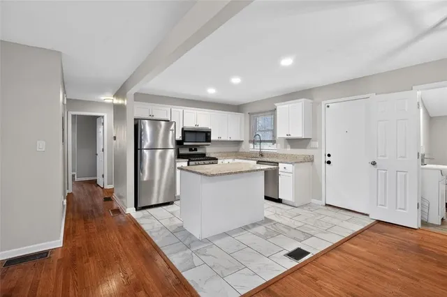 a kitchen with granite countertop a refrigerator and a sink