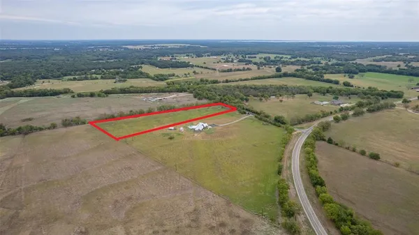 an aerial view of a residential houses with outdoor space and river