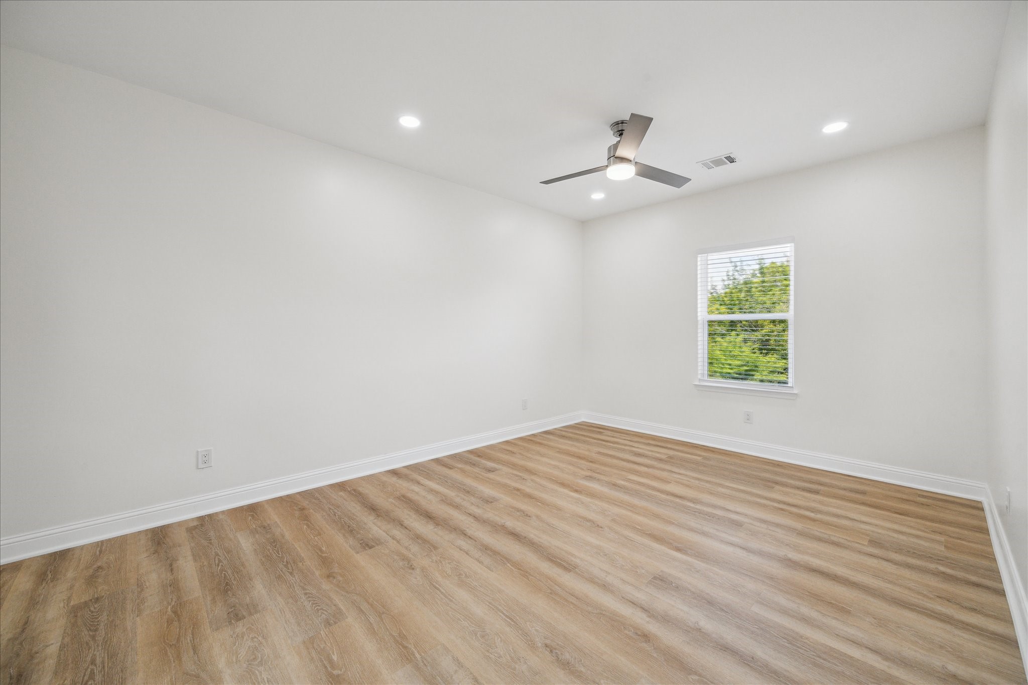 901 East 37th Street Houston, TX 77022 - Photo 13 of 19 an empty room with wooden floor ceiling fan and windows