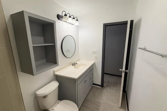 a bathroom with a toilet sink and mirror
