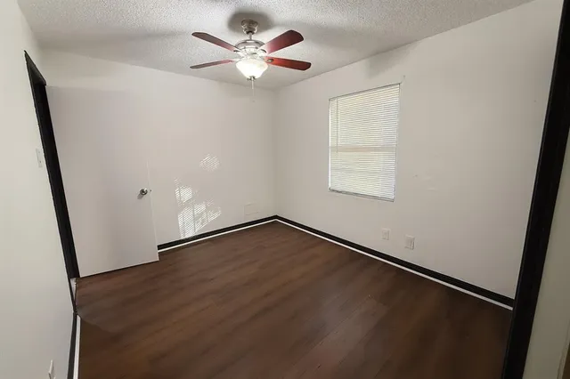 an empty room with wooden floor and window