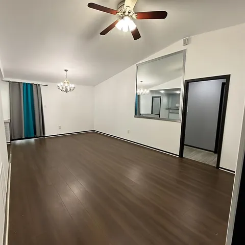 a view of a livingroom with wooden floor and a ceiling fan
