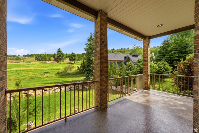 3535 Homestead Road Park City, UT 84098 - Photo 31 of 81 Covered outdoor patio with exposed aggregate flooring, supported by brick columns, and featuring a metal railing