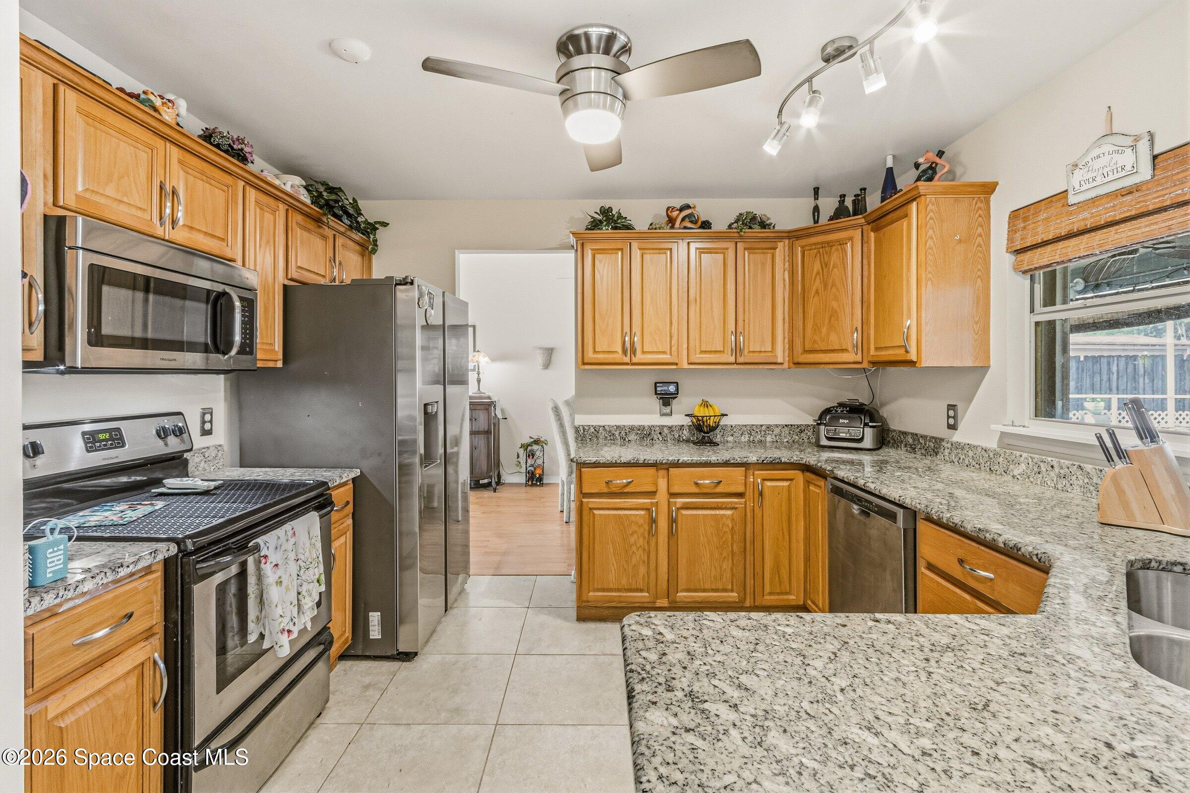 4770 Hidden Creek Road Palm Shores, FL 32935 - Photo 20 of 51 a kitchen with stainless steel appliances granite countertop a sink a stove a refrigerator cabinets and a dining table