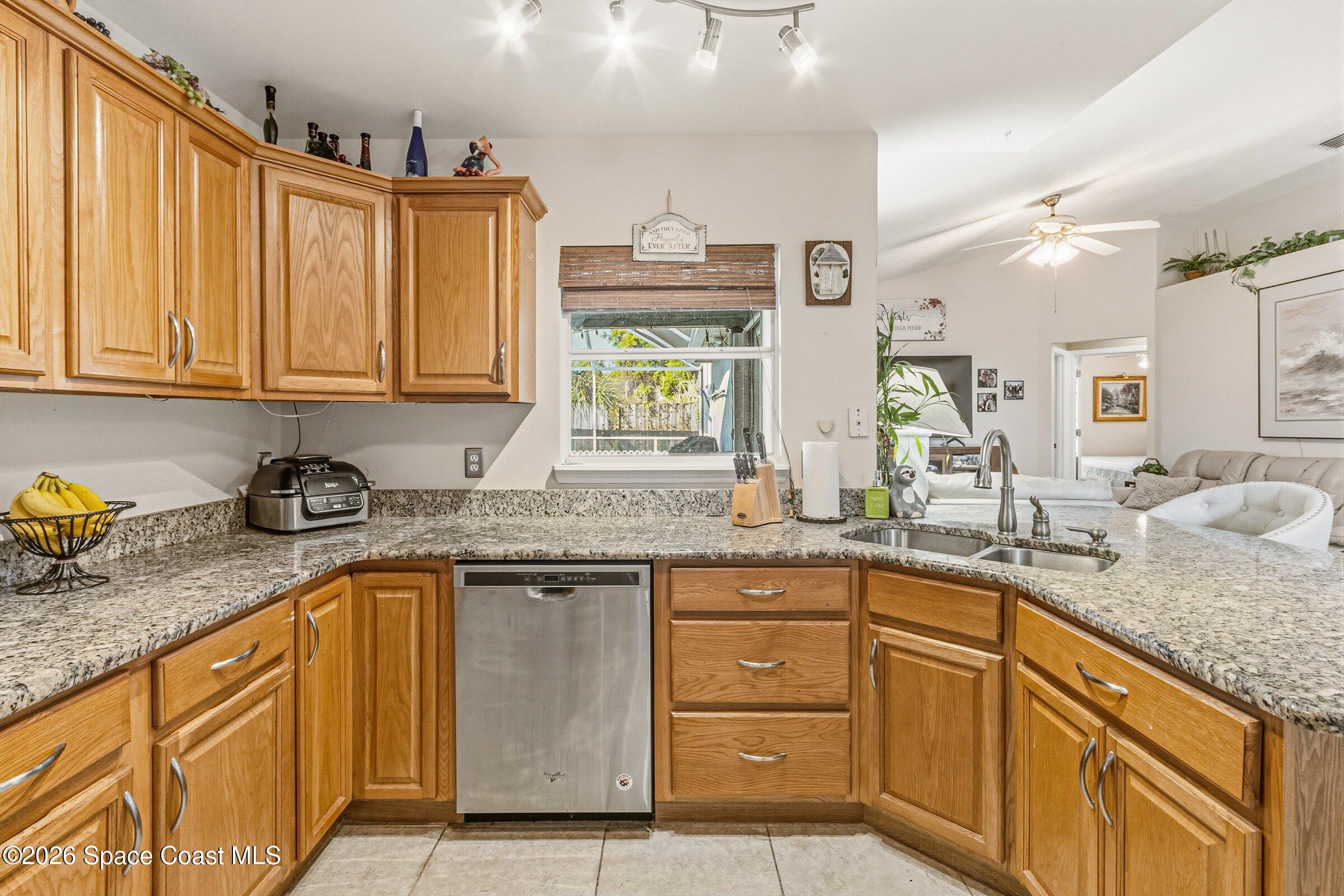 4770 Hidden Creek Road Palm Shores, FL 32935 - Photo 21 of 51 a kitchen with granite countertop stainless steel appliances a sink window and cabinets