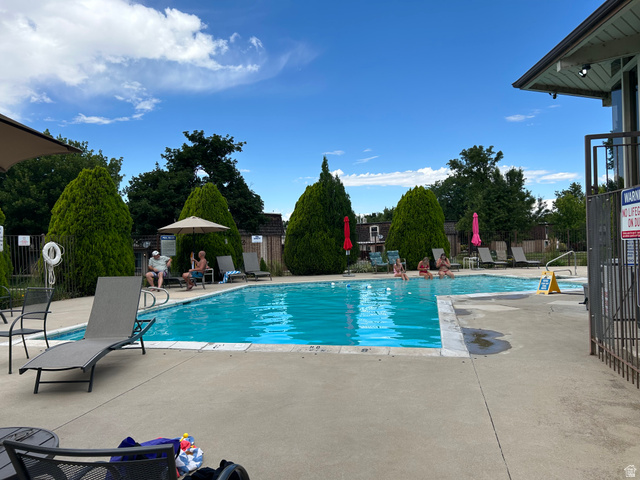 88 West 50 South, Unit C1 Centerville, UT 84014 - Photo 3 of 16 Outdoor swimming pool with concrete decking, surrounding perimeter fencing, and mature landscaping