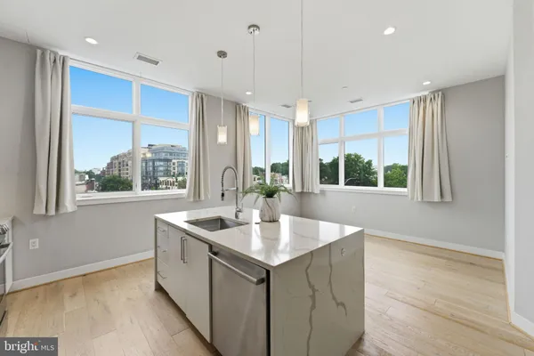 a kitchen with stainless steel appliances granite countertop a sink and a large window