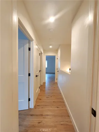 a view of a hallway with wooden floor