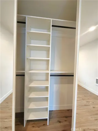a view of walk in closet with empty racks