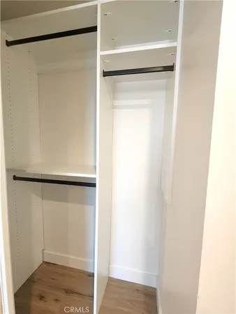a view of walk in closet with wooden floor
