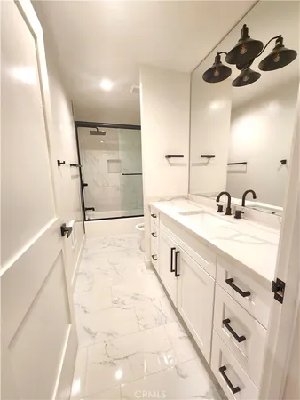 a spacious bathroom with a double vanity sink a mirror and shower