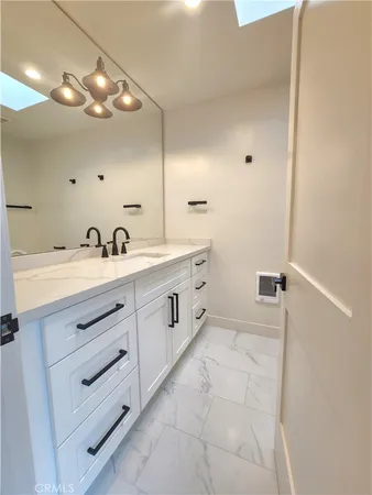 a spacious bathroom with a double vanity sink a mirror and a bathtub