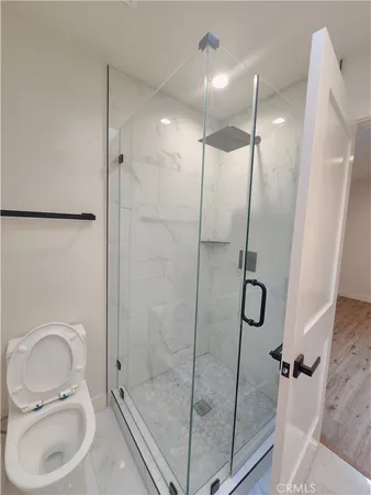 a bathroom with a shower a toilet and sink