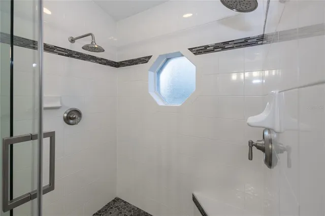 an empty room with a chandelier fan and wooden floor