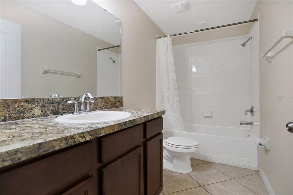 3216 Rodrick Circle Orlando, FL 32824 - Photo 16 of 33 a bathroom with a granite countertop sink toilet and shower