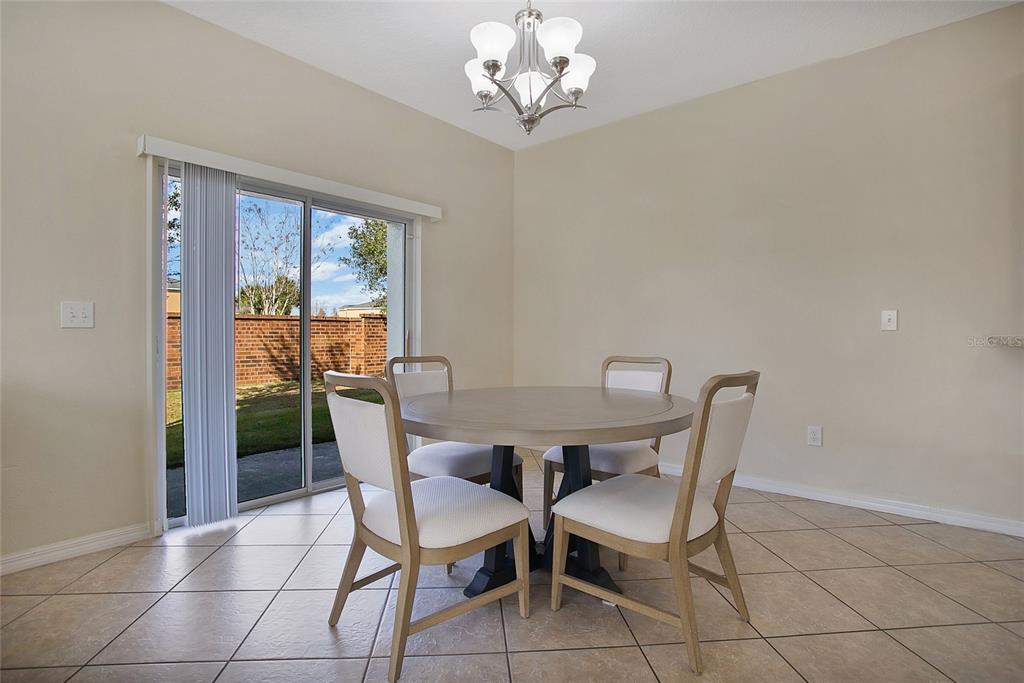 3216 Rodrick Circle Orlando, FL 32824 - Photo 6 of 33 a view of a dining room with furniture a chandelier and window