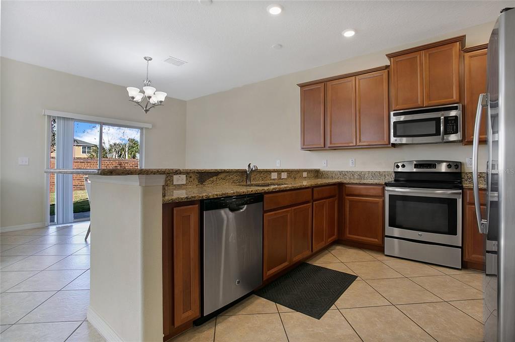 3216 Rodrick Circle Orlando, FL 32824 - Photo 8 of 33 a kitchen with stainless steel appliances granite countertop a stove and cabinets
