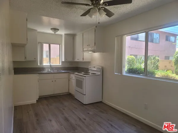 a kitchen with a white cabinets and window