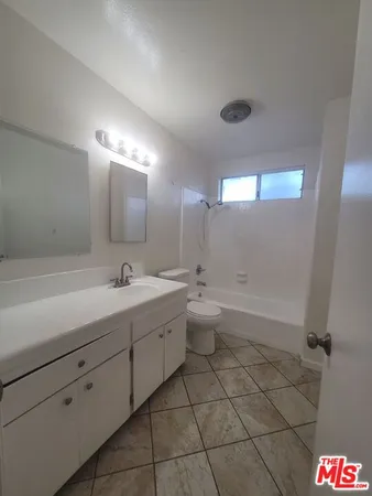 a spacious bathroom with a bathtub sink mirror and toilet
