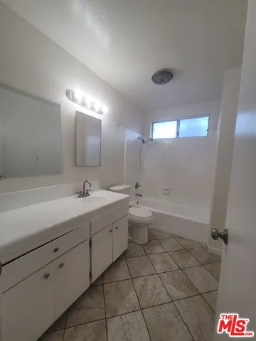 a spacious bathroom with a bathtub sink mirror and toilet