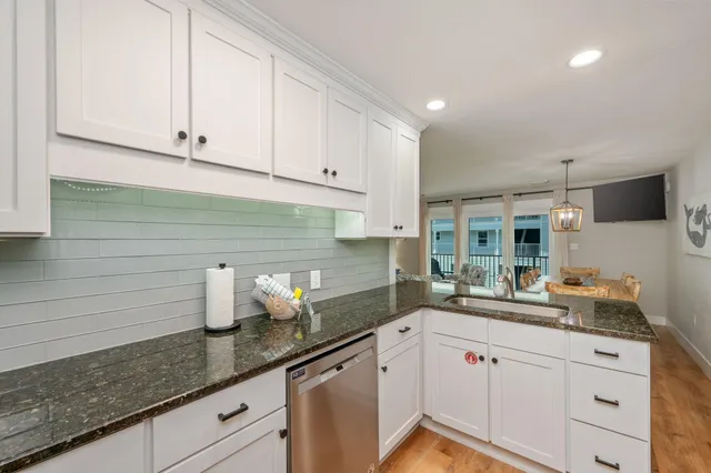 a kitchen with stainless steel appliances granite countertop white cabinets sink and dishwasher