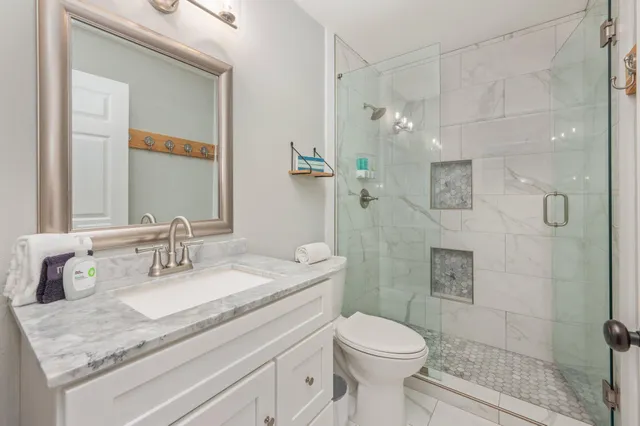 a bathroom with a granite countertop sink toilet and shower