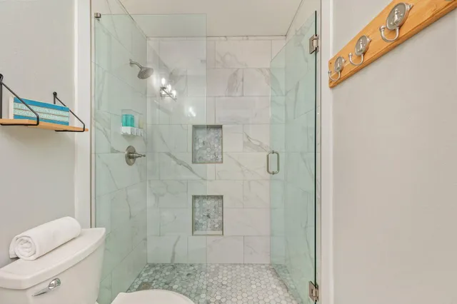 a bathroom with a granite countertop shower a toilet and a sink