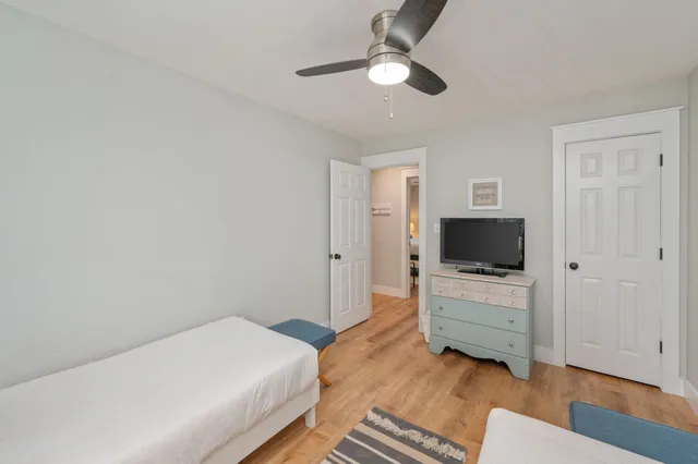 a bedroom with a bed and a flat tv screen on dresser