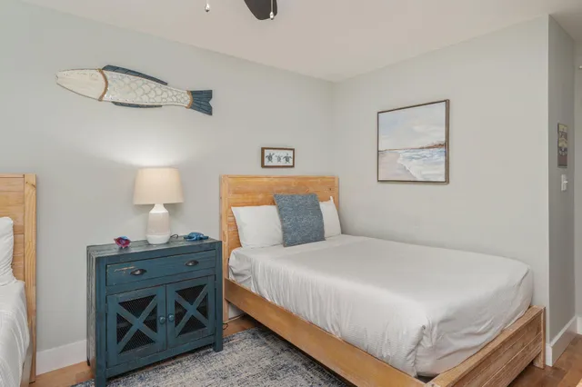 a bedroom with a bed and a lamp on the dresser