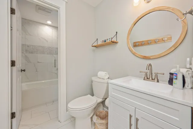 a bathroom with a sink a toilet and a mirror